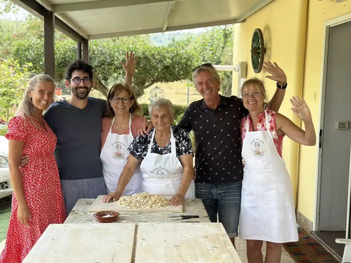 A close-up shot of a grandmother's hands skillfully making fresh pasta on a wooden board.